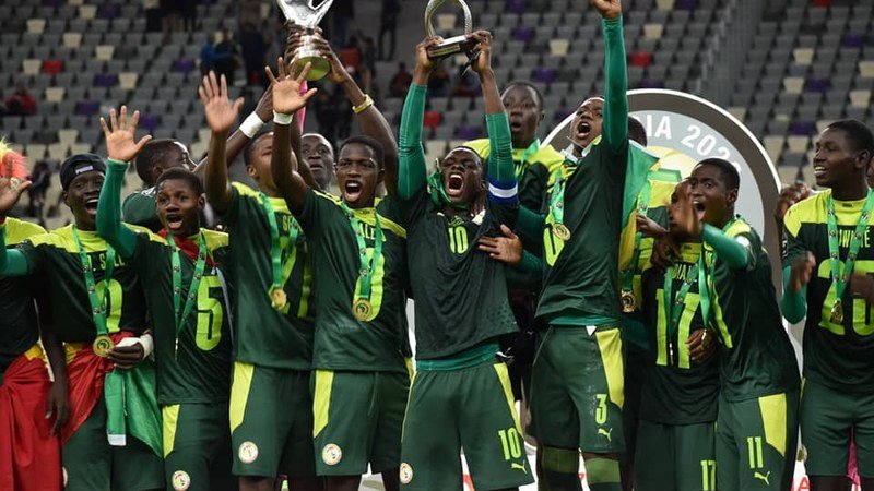 Gros plan sur un jeune footballeur africain talentueux lors de la CAN U17, affichant une détermination sur le terrain.