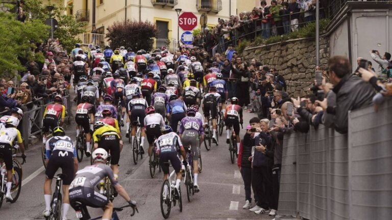 Chute massive de coureurs cyclistes lors d'une étape du Giro d'Italia, vélos et athlètes au sol sur la route.