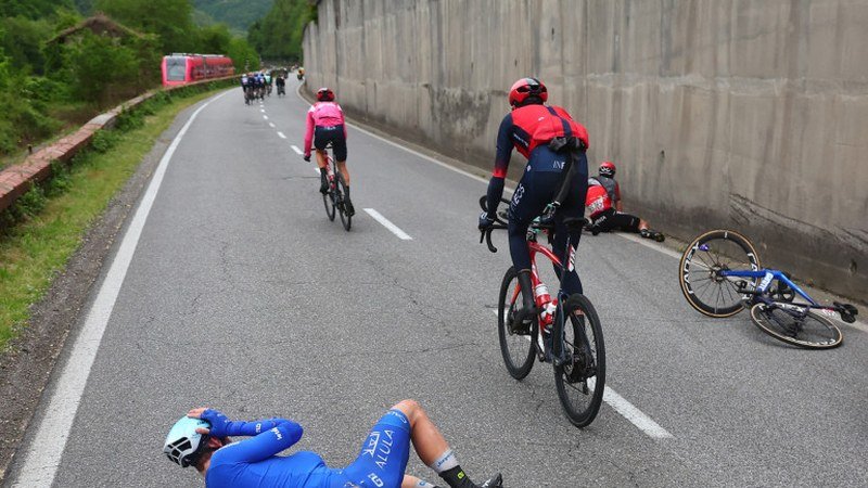 Image d'un cycliste du Giro d'Italia en phase de récupération rapide ou de retour à la compétition après une chute, en action sur son vélo.