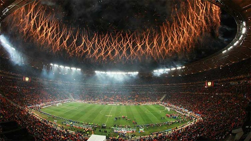 Ambiance spectaculaire d'un grand stade de football lors d'une finale majeure, foule immense et lumières