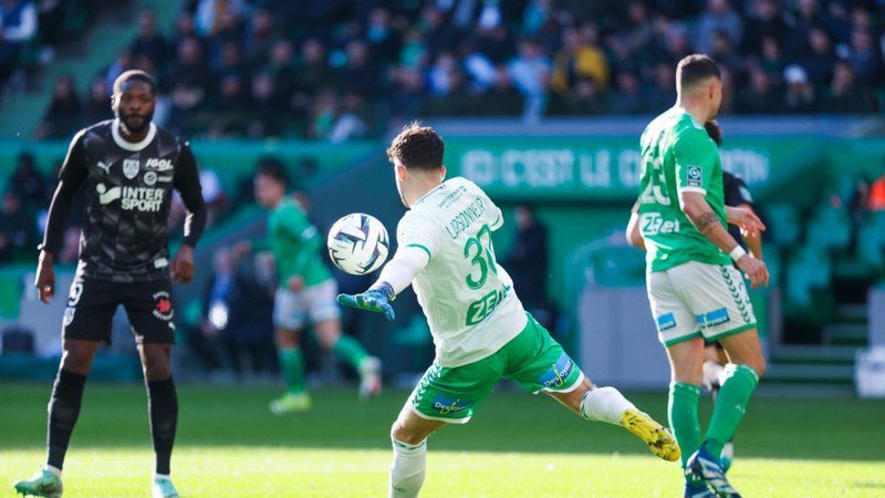 Gautier Larsonneur célébrant un but ou une victoire avec l'équipe de l'AS Saint-Étienne sur le terrain de football.