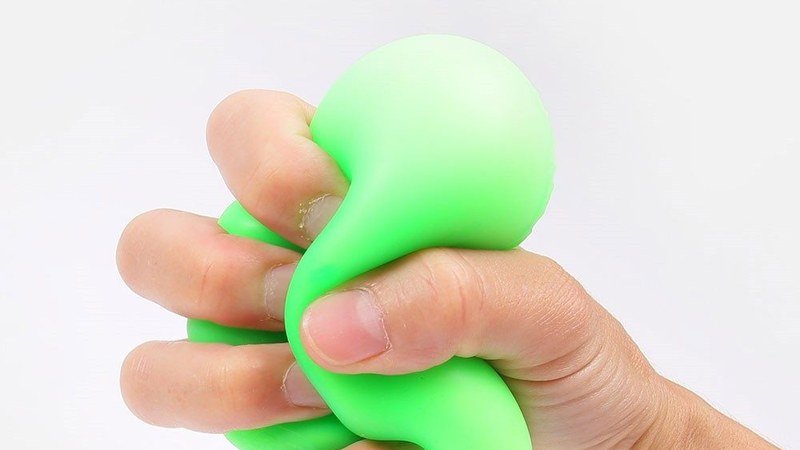 Main d'adulte tenant un jouet Needoh anti-stress